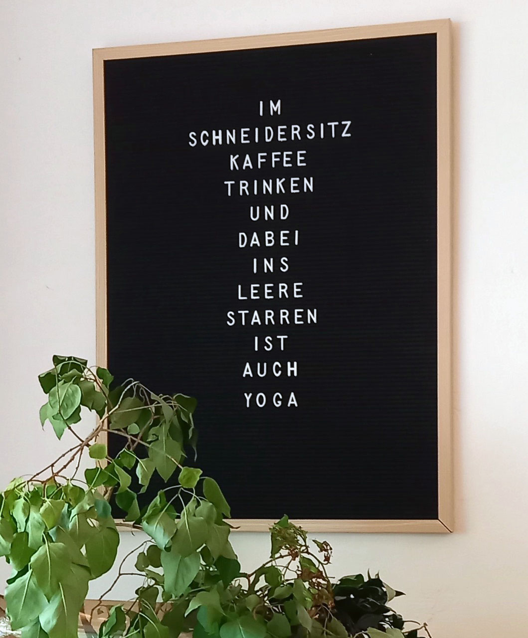 Barbara Lehmann - Transformationsbooster Tafel an der Wand mit dem Schriftzug: "Im Schneidersitz Kaffee trinken und dabei ins Leere starren ist auch Yoga."